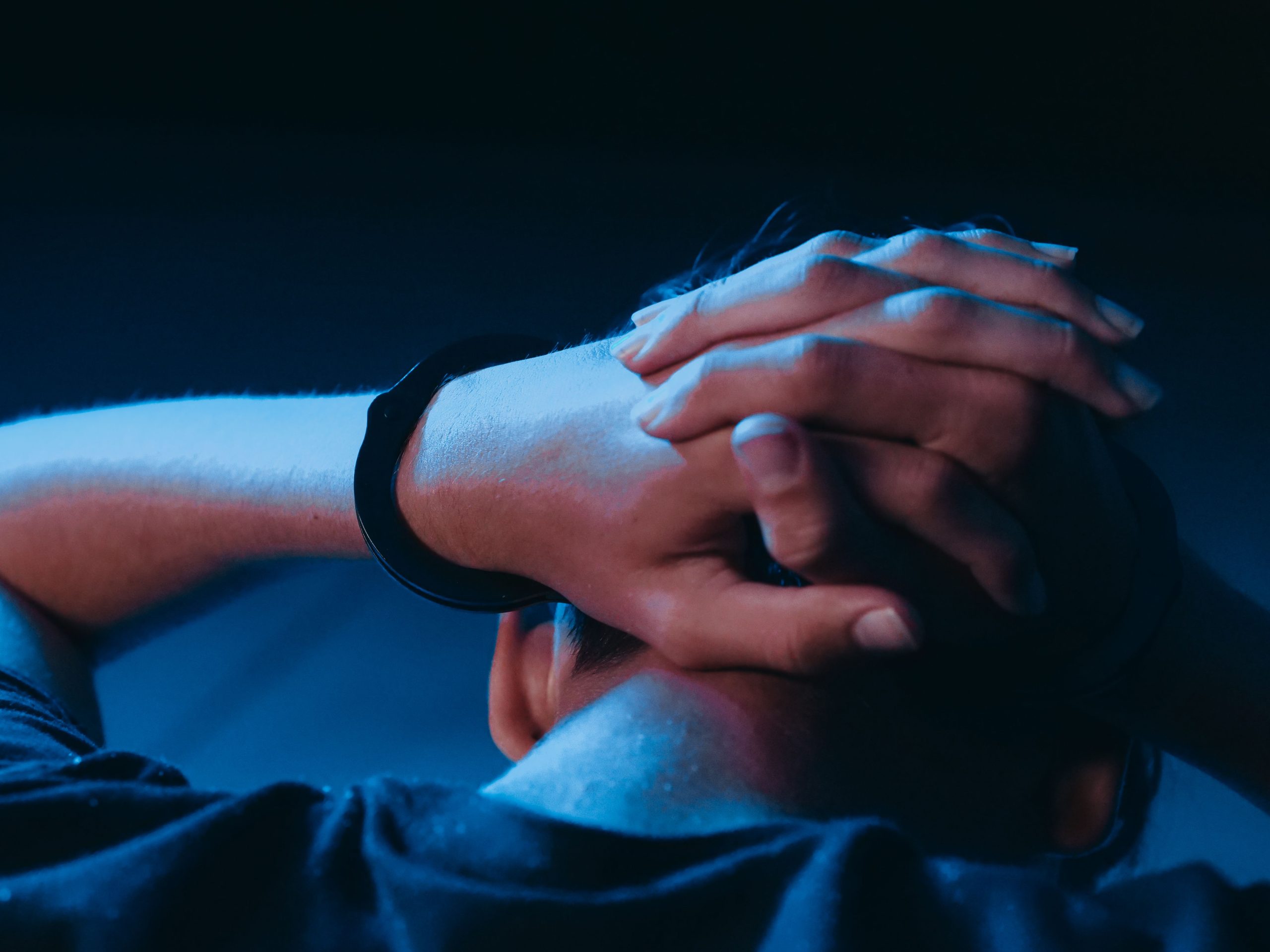 Persona de espaldas con las manos esposadas, sin rostro visible